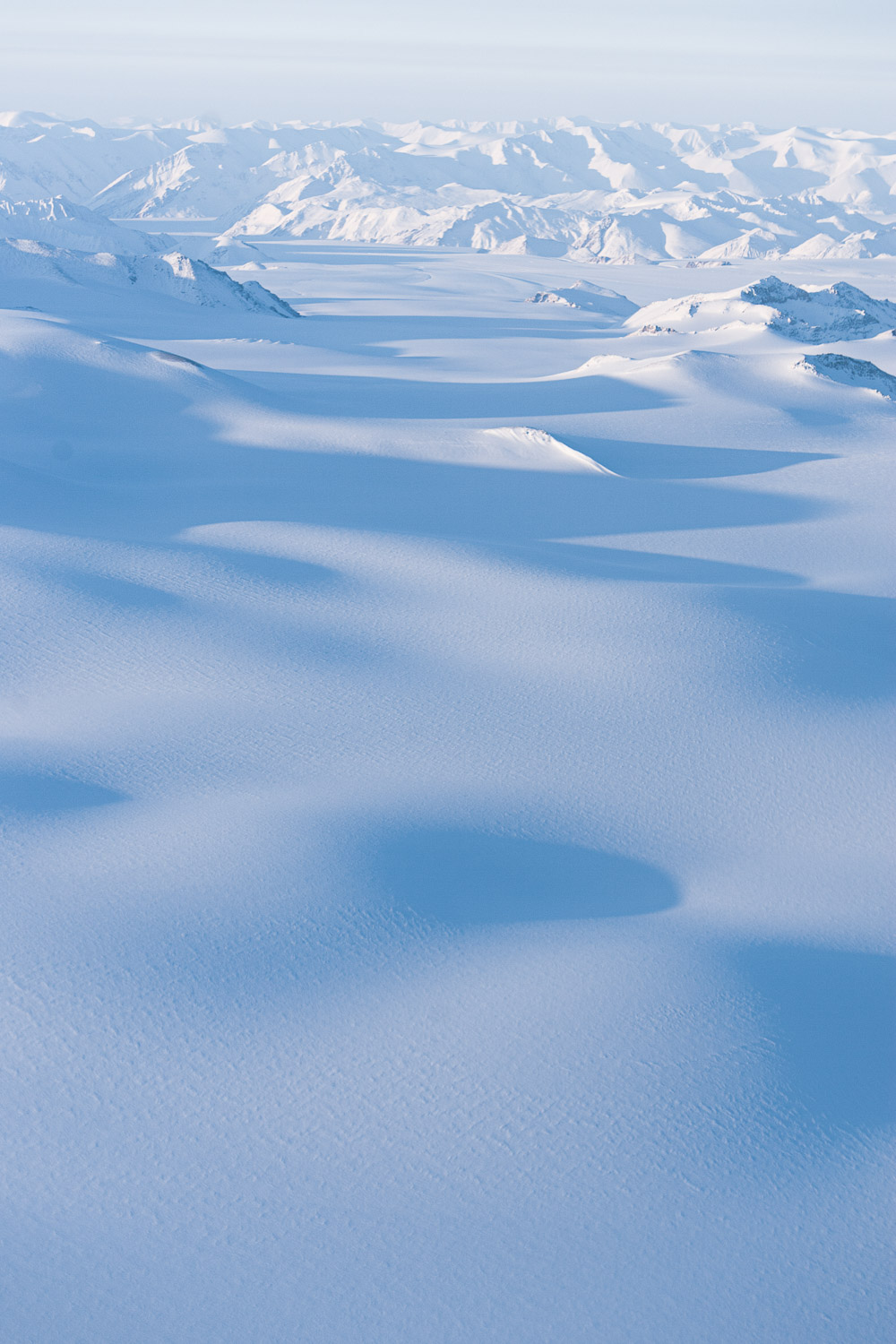 Aerial photo of snow-covered mountainand glacier with deep shadowed valley. Ellesmere Island, High Arctic, Canada, Op NUNALIVUT 2008.