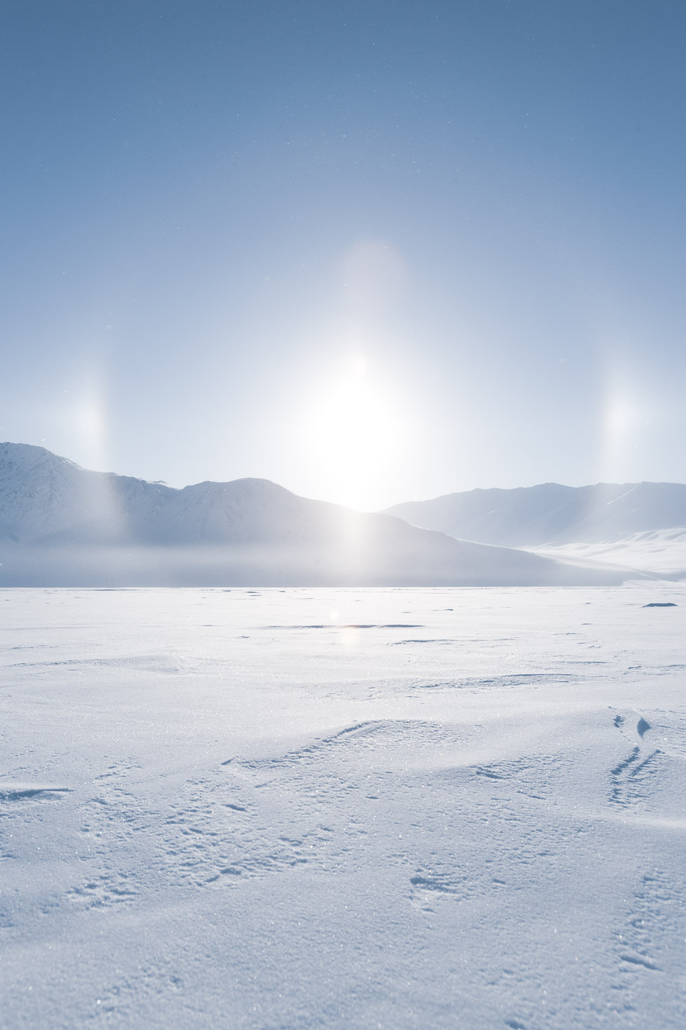 Sundog halo above Arctic sea ice with silhouetted mountains. Ellesmere Island, High Arctic, Canada, Op NUNALIVUT 2008.