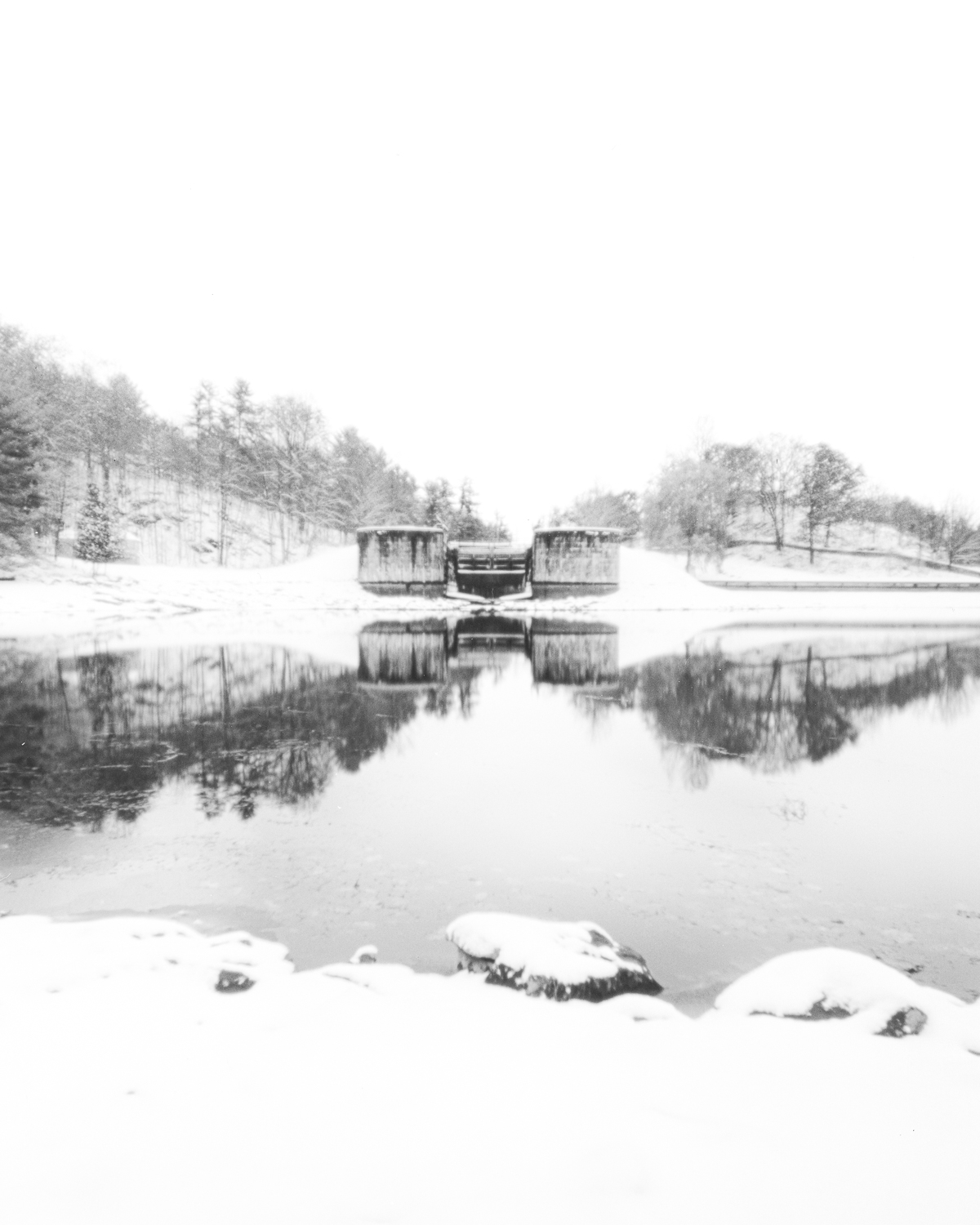 Long-exposure pinhole photograph looking upstream from Jones Falls on the Rideau Canal, soft water and blurred reflections in early winter.
