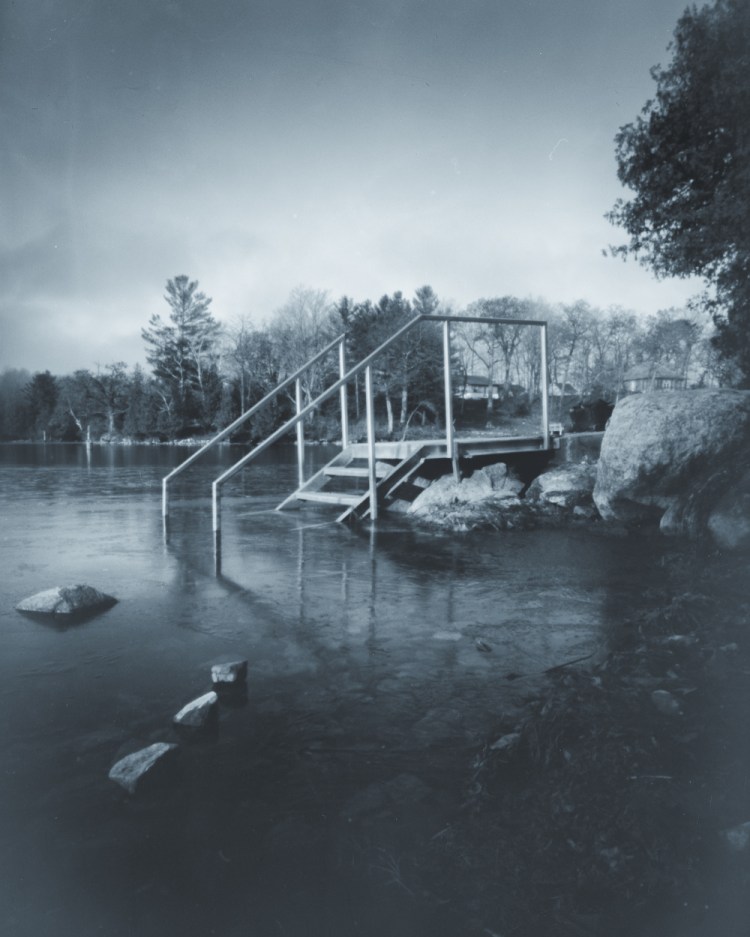 Metal staircase leading into thin ice on the Rideau Canal at Haskin’s Point, Seeley’s Bay, photographed in winter.