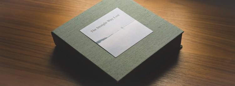 Custom linen-bound presentation box for The Straight Way Lost artist book on a wooden surface.