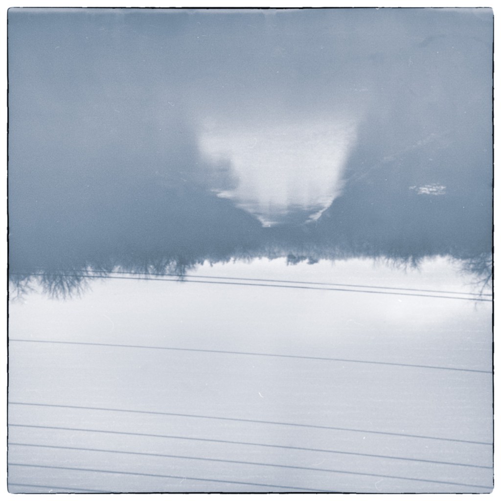 Inverted long-exposure black and white photograph of the Rideau Canal near Newboro Lock, viewed from the Highway 42 bridge with overhead utility lines crossing the frame.