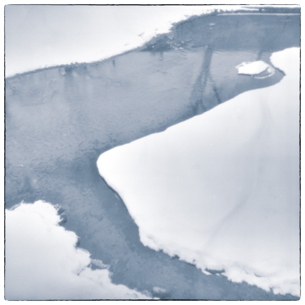 Long-exposure black and white photograph of partially frozen water and snow within the drained basin area of the Smiths Falls Combined Lockstation.