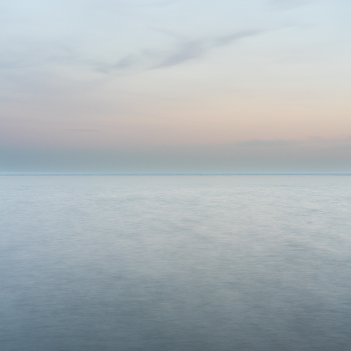 Soft pastel horizon over calm Lake Ontario water at dusk, photographed from Upper Gap Archaeological Site with a long exposure.