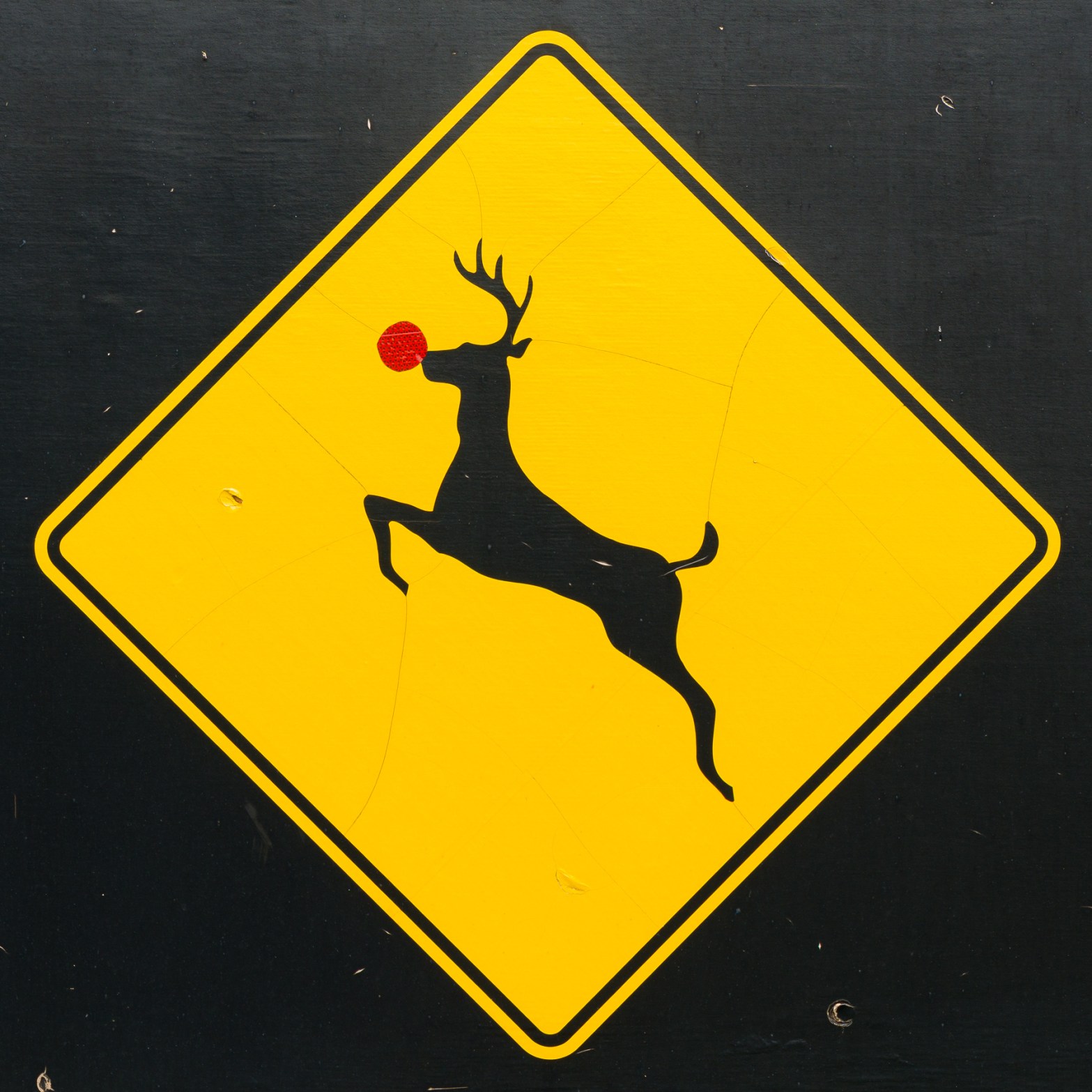 Deer crossing sign altered with a red reflective nose