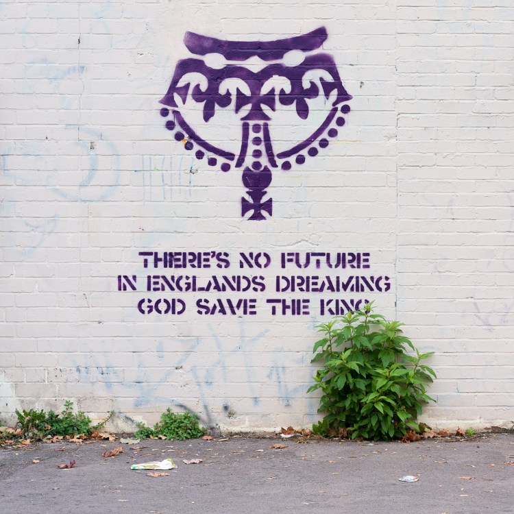 Street artwork reading “No Future in England’s Dreaming” and “God Save the King” on a wall in Bristol.