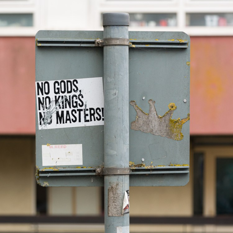 “No Gods, No Kings, No Masters” sticker attached to an official street sign in Bristol.