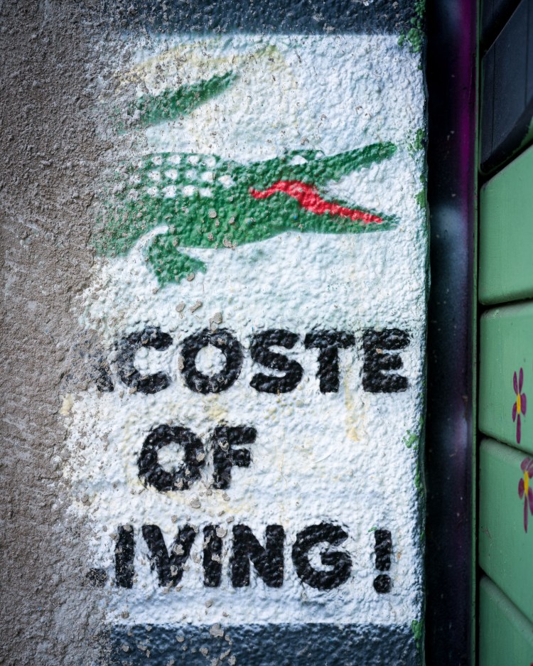 Green crocodile graphic with the words “Coste of Living!” painted on a wall in Bristol.