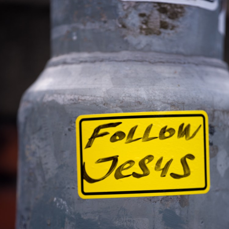 Street intervention reading “Follow Jesus” on a surface in Bristol.