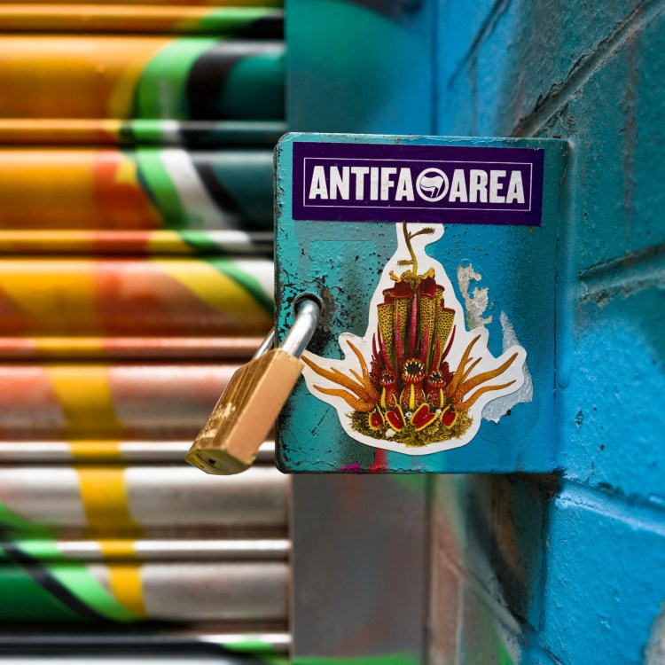 “Antifa Area” sticker on a locked blue metal surface in Bristol.