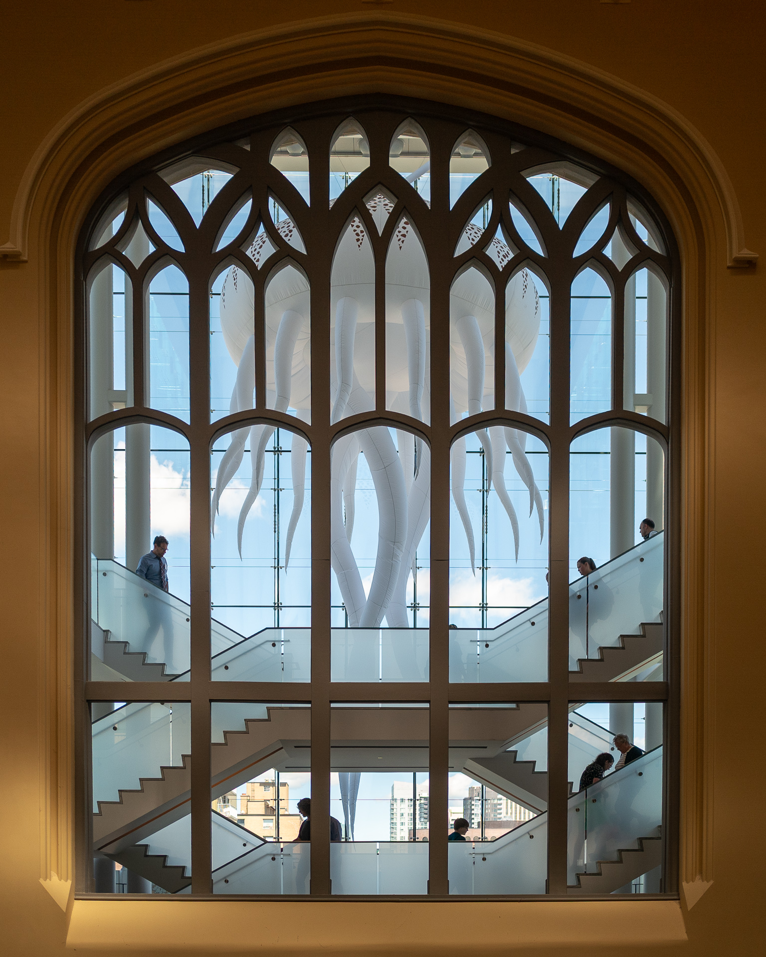Giant white jellyfish installation seen through a Gothic arched window inside the Canadian Museum of Nature in Ottawa.